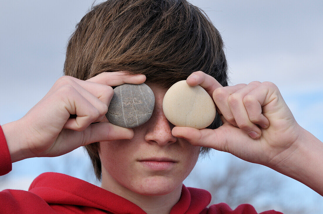 Teenage Boy holding Stones over Eyes,Sete,France