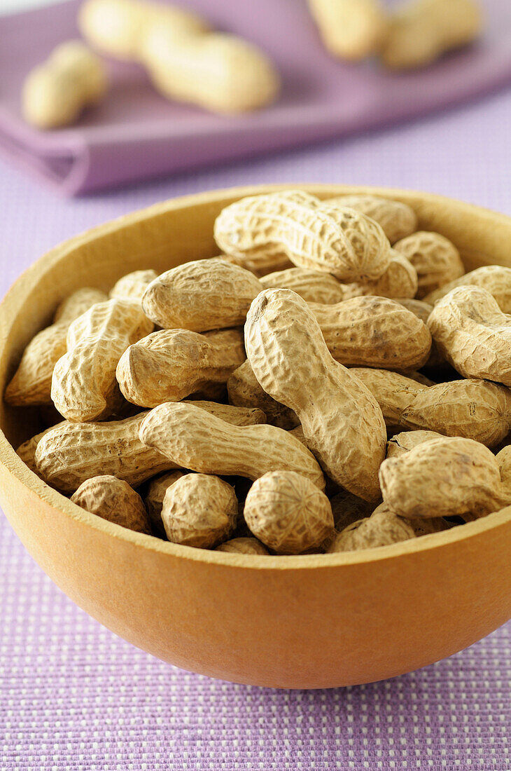 Close-up of Bowl of Peanuts on Purple Background,Studio Shot