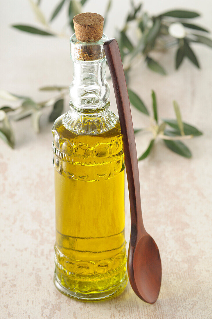 Flasche Olivenöl mit Holzlöffel