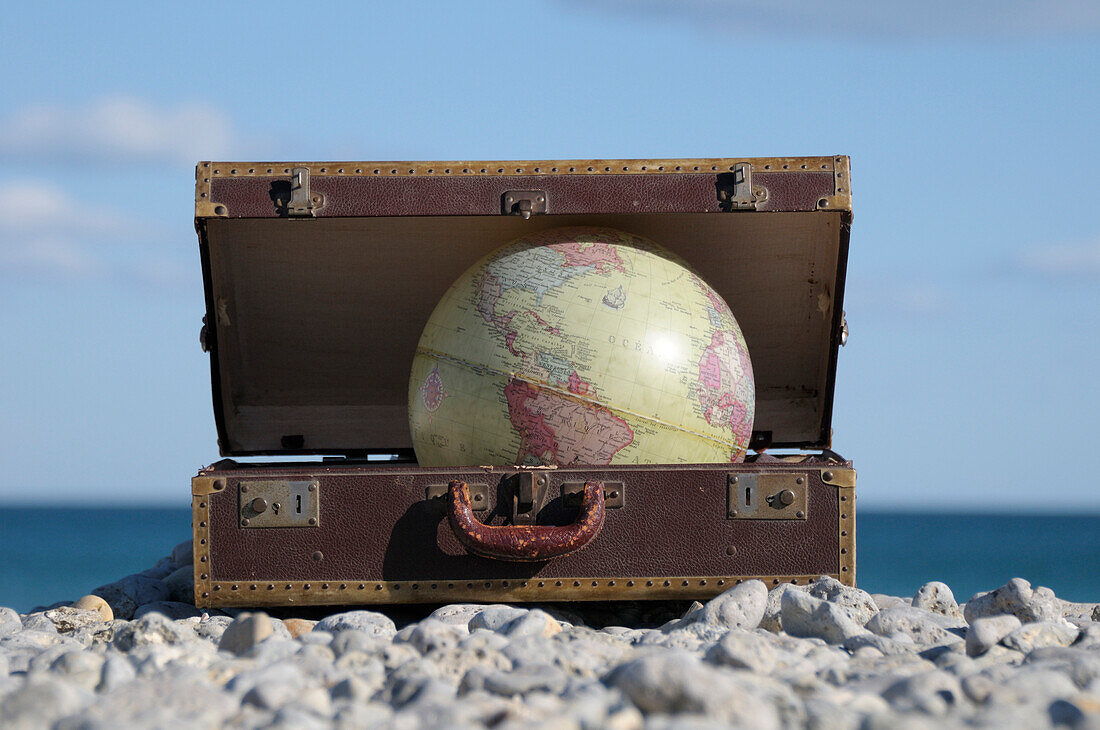 Globus im Koffer am felsigen Strand, Frontignan, Herault, Frankreich
