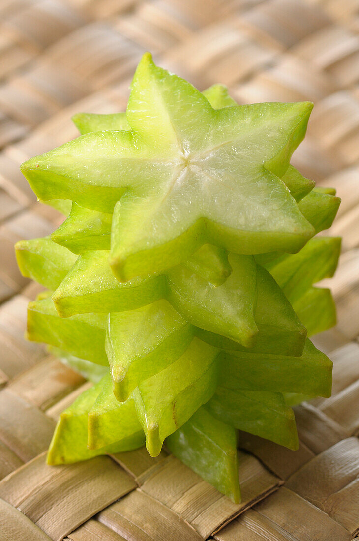 Close-up of Stacked Slices of Starfruit on Woven Background
