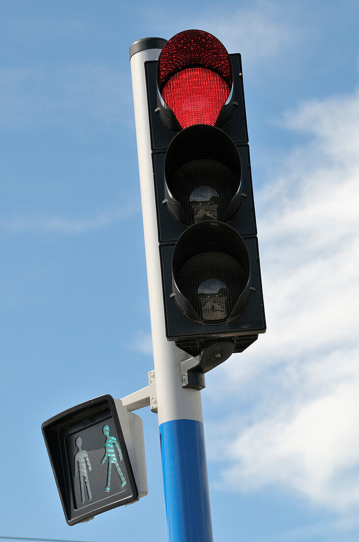Nahaufnahme einer Ampel mit Stopplicht und Fußgängerzeichen
