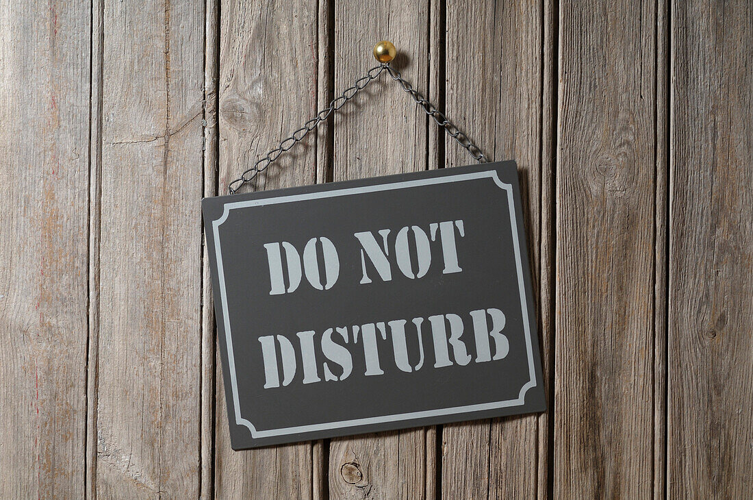 Do Not Disturb Sign Hanging on Wooden Wall