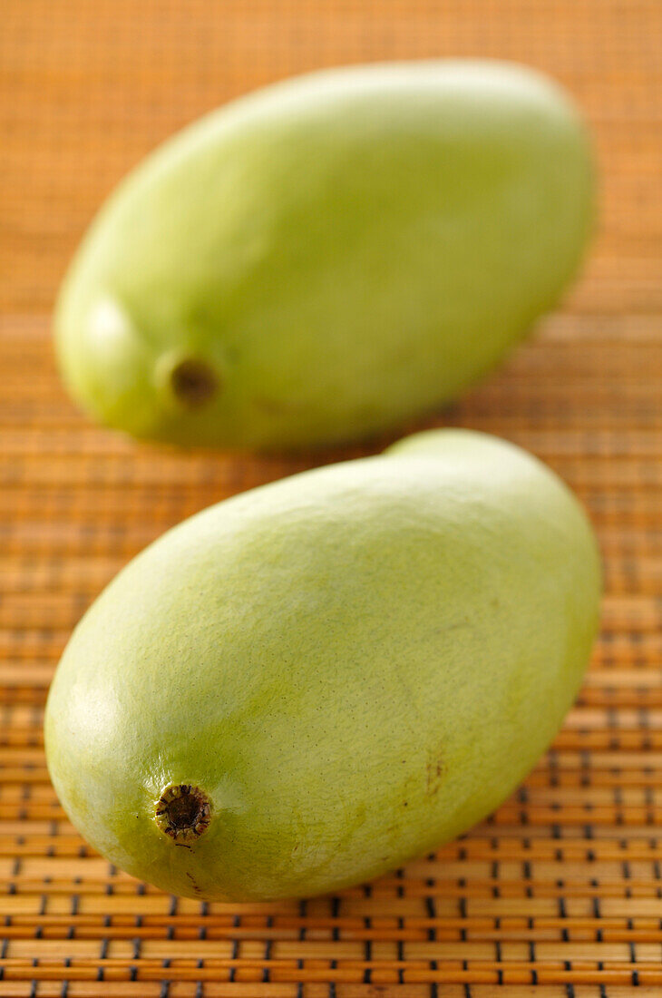 Nahaufnahme von zwei grünen Mangos
