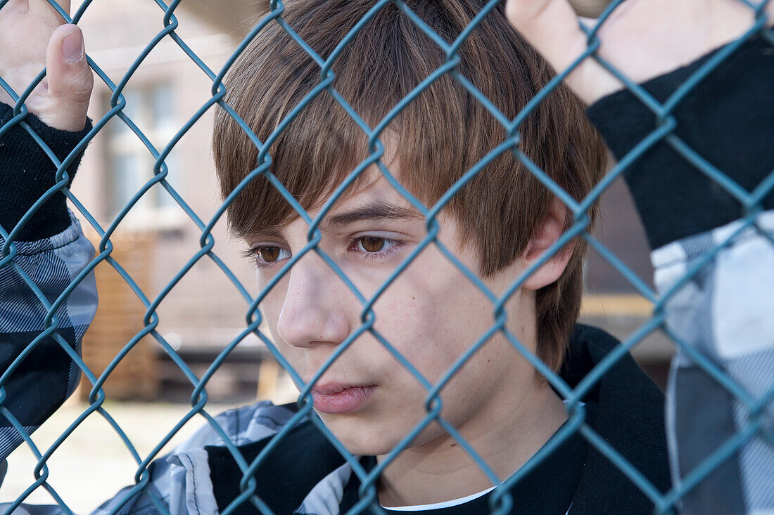 Close-Up of Boy Behind Fence
