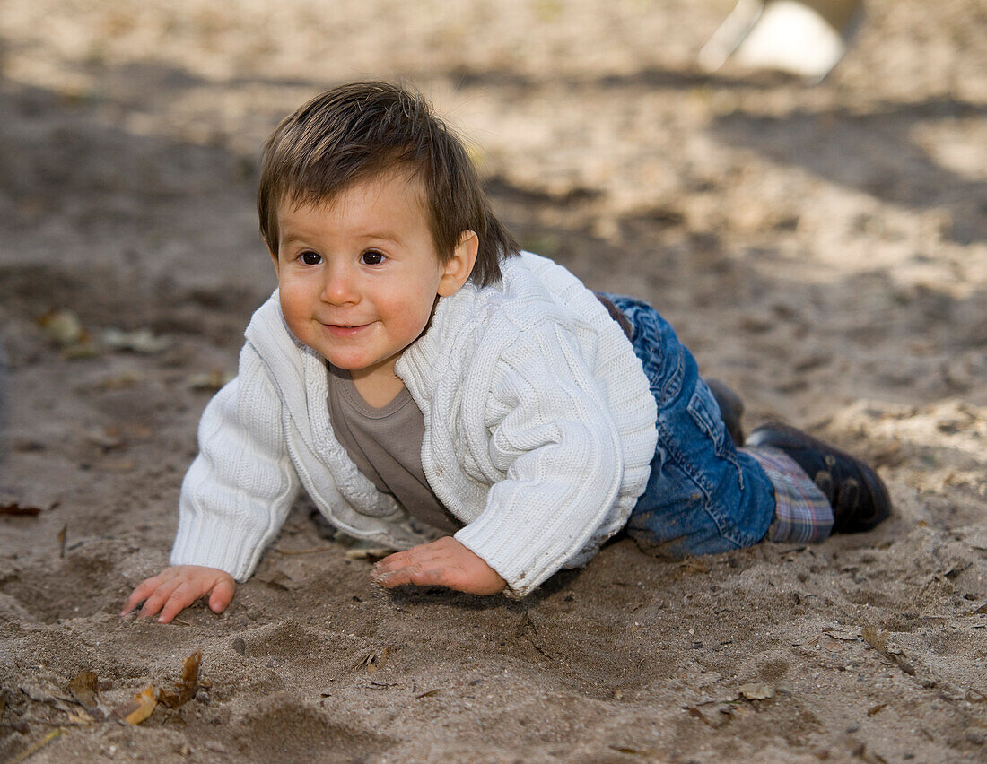 Junge krabbelt im Sand
