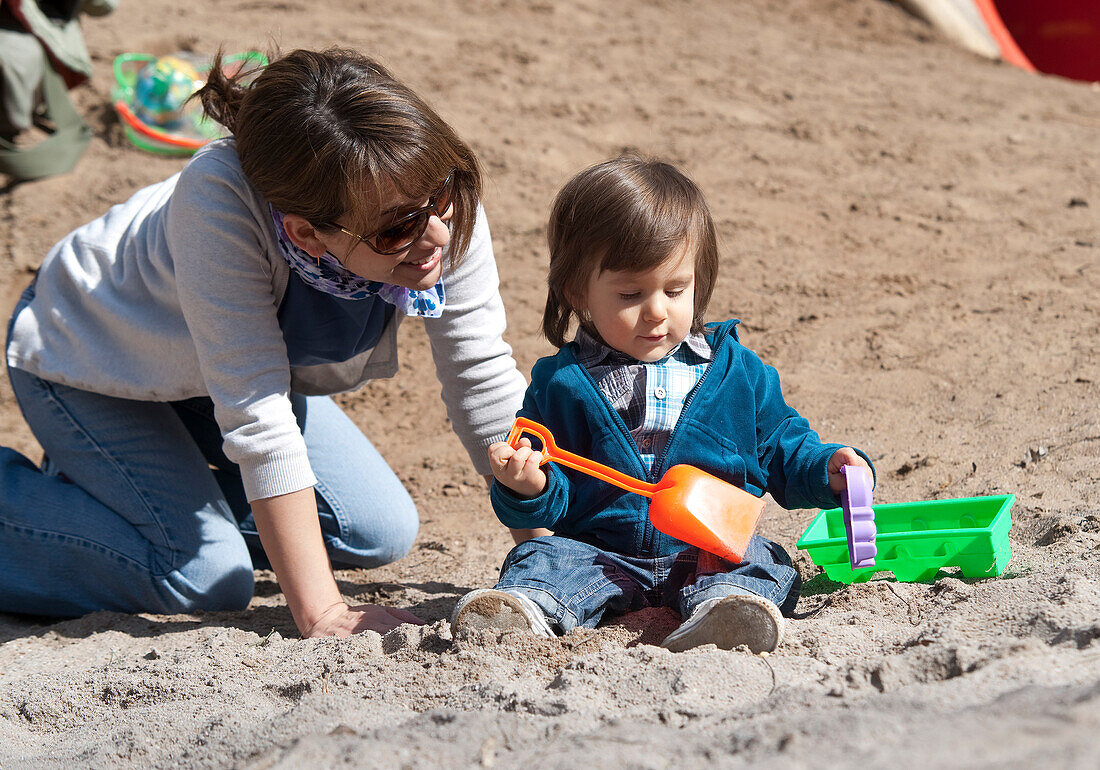 Mutter und Sohn spielen im Sand