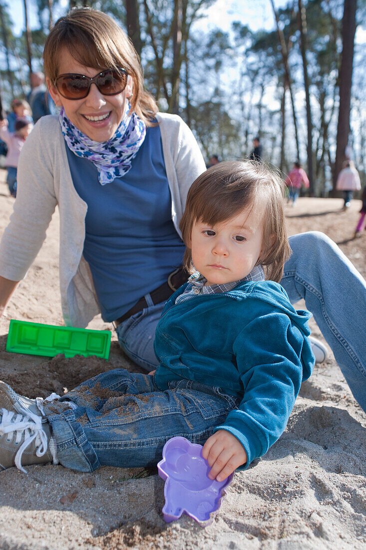 Mutter und Sohn spielen im Sand