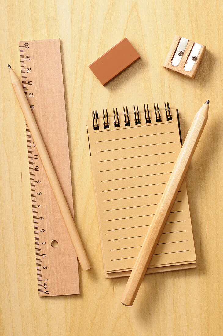 Notizbuch, Lineal und Bleistifte auf hölzernem Hintergrund, Studioaufnahme