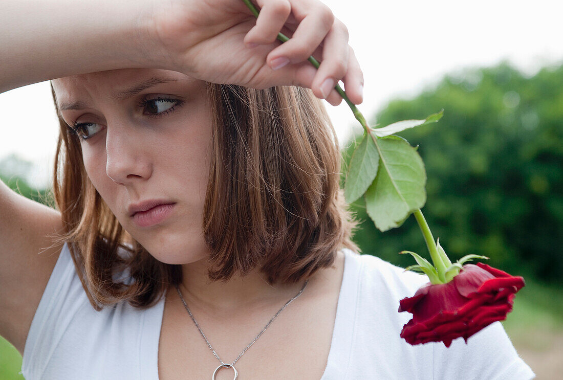 Teenage Girl Holding a Red Rose