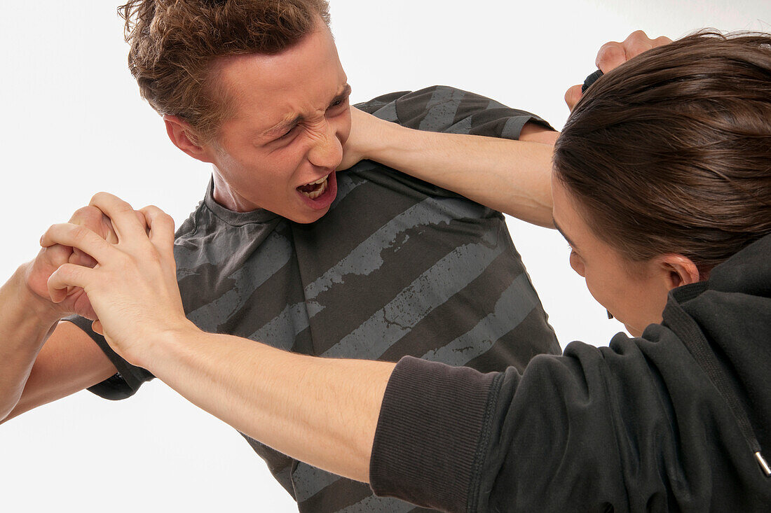 Close-up of two young men fighting,studio shot on white background