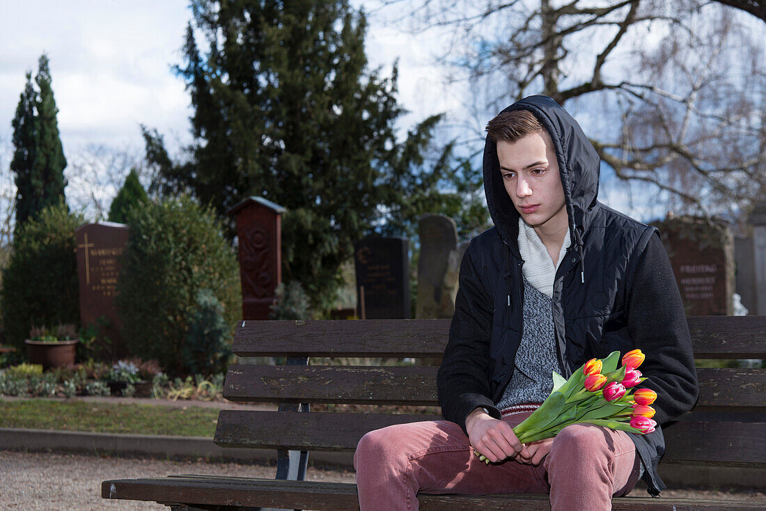 Teenager Sitting on Bench in Cementery