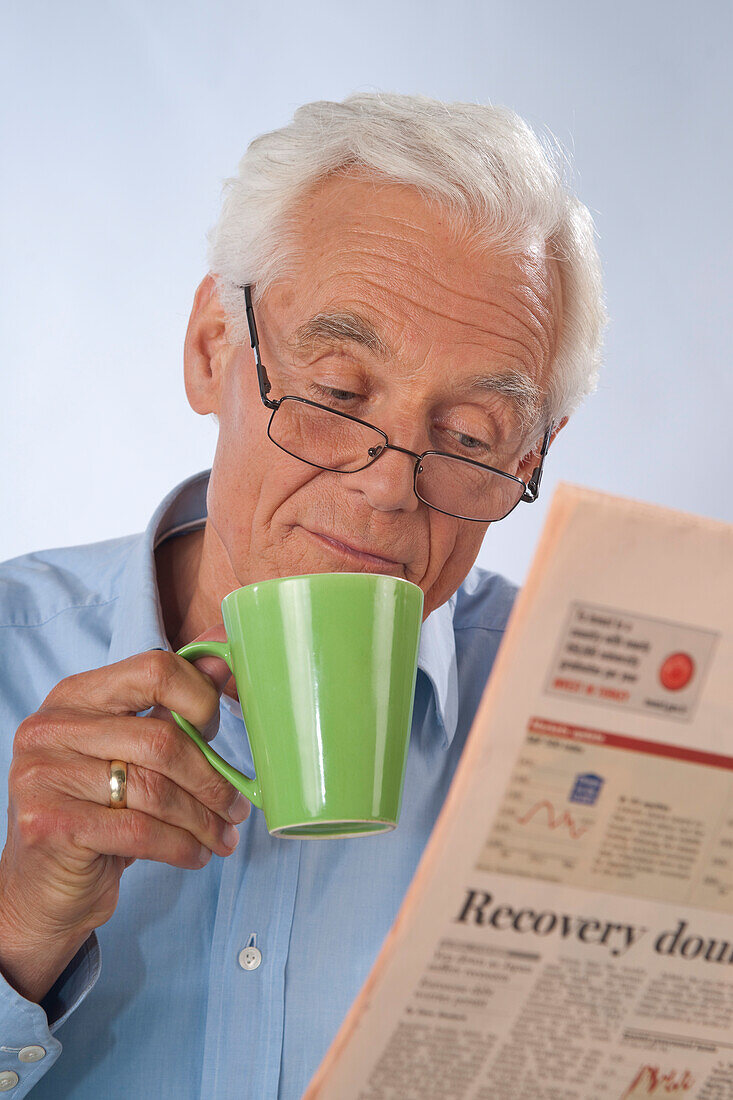 Mann, der Kaffee trinkt und Zeitung liest