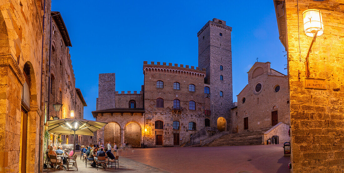 View of restaurants in Piazza del Duomo at dusk,San Gimignano,UNESCO World Heritage Site,Province of Siena,Tuscany,Italy,Europe