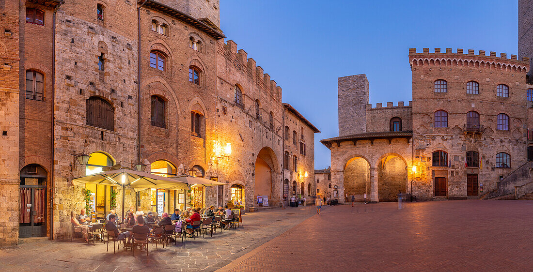 Blick auf Restaurants auf der Piazza del Duomo in der Abenddämmerung, San Gimignano, UNESCO-Welterbe, Provinz Siena, Toskana, Italien, Europa