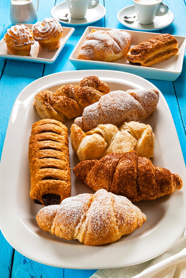 Italian breakfast with pastries,croissant,puff pastry (sfoglia) with chocolate,puff pastry (sfoglia) with cream,rice puddings (budini di riso) and espresso,Italy,Europe