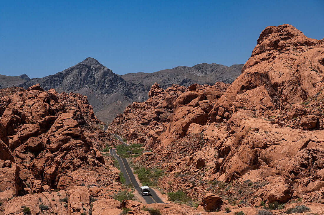An RV Camper Van Recreational Vehicle travels the highway of Mouse's Tank Road through the Valley of Fire State Park,Nevada,United States of America,North America