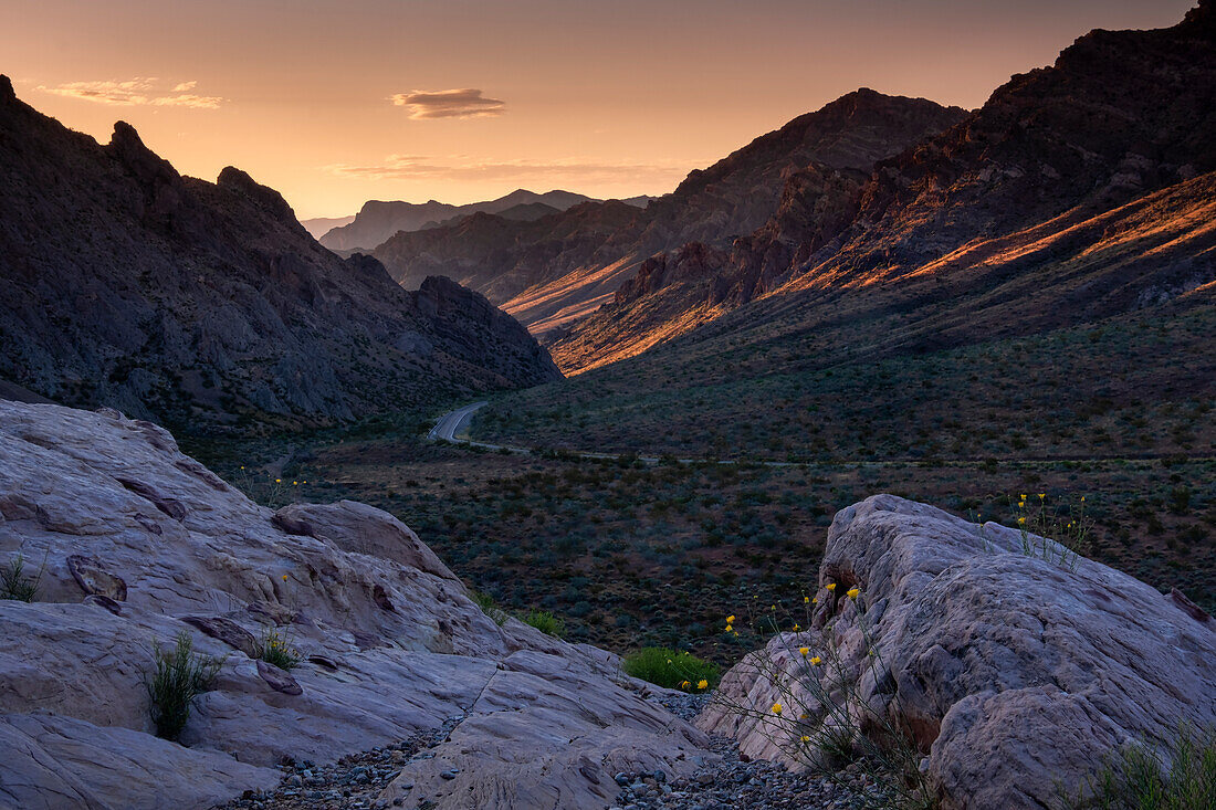 Sonnenaufgang beleuchtet den Pass durch die Berge am westlichen Eingang zum Valley of Fire State Park, Nevada, Vereinigte Staaten von Amerika, Nordamerika