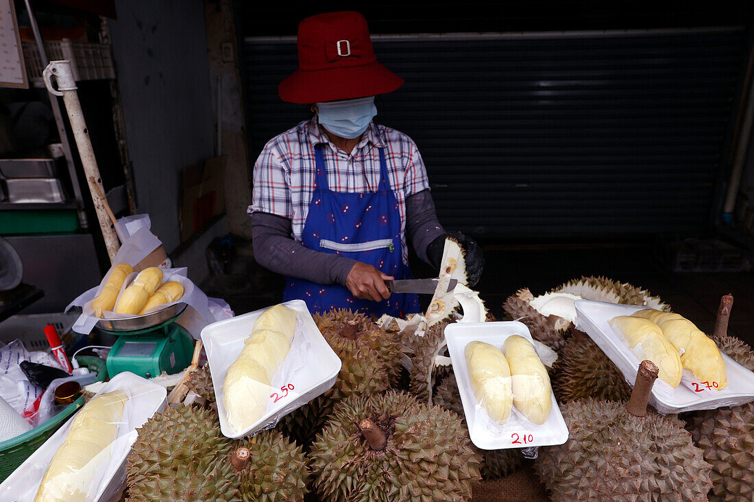 Eine Frau bereitet Durian-Früchte für den Verkauf an einem bei Touristen und Einheimischen beliebten Straßenverkaufsstand vor,Bangkok,Thailand,Südostasien,Asien