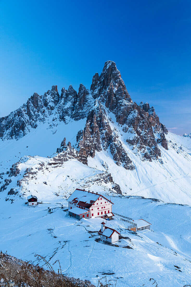 Dusk on Locatelli mountain hut with Paterno mountain in the background,winter view,Tre Cime di Lavaredo (Lavaredo peaks),Sesto (Sexten),Dolomites,South Tyrol,Italy,Europe