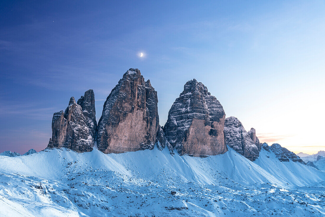 Moon above Tre Cime di Lavaredo at dusk,winter time,Tre Cime di Lavaredo (Lavaredo peaks) (Drei Zinnen),Sesto (Sexten),Dolomites,South Tyrol,Italy,Europe