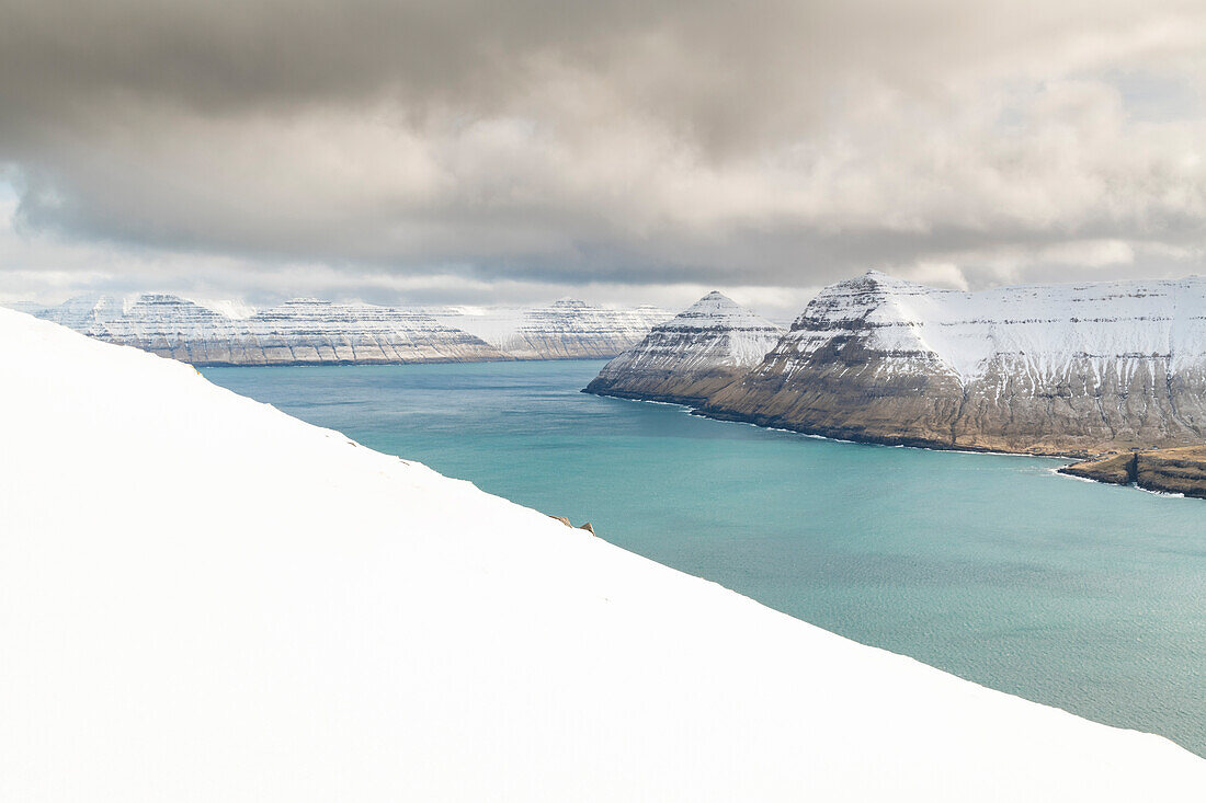 Schneebedeckte Klippen und Berge entlang des Funningur Fjords, Eysturoy Island, Färöer Inseln, Dänemark, Europa