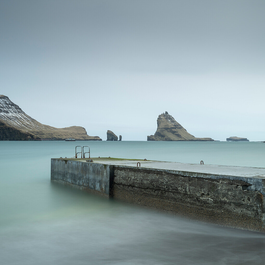 Pier und Schornsteine von der Küste von Bour, Vagar Island, Färöer Inseln, Dänemark, Europa