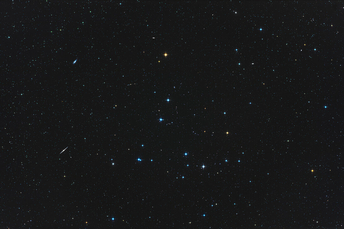 The Coma Berenices star cluster,aka Melotte 111,in the constellation of Coma Berenices,here in a field of view wide enough (7.5° by 5°) to frame it with some of the surrounding galaxies,in particular the edge-on galaxy NGC 4565 at lower left and NGC 4559 at upper left. Several other fainter galaxies are in the field,some between 12th to 14th magnitude,such as the tiny quartet of Box Galaxies at the extreme upper right corner. Melotte 111 is one of the nearer star clusters,being only 288 light years away. The field is similar to that of binoculars.
