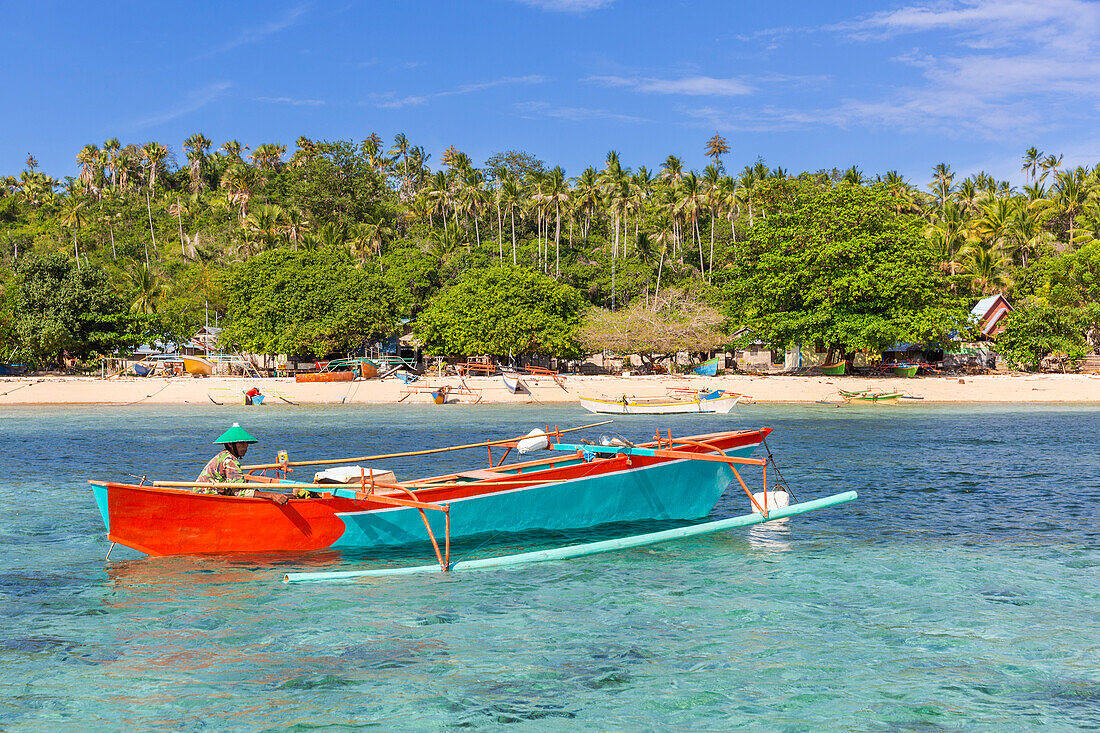 Local fisherman in outrigger boat in the shallow reefs off Bangka Island,off the northeastern tip of Sulawesi,Indonesia,Southeast Asia,Asia