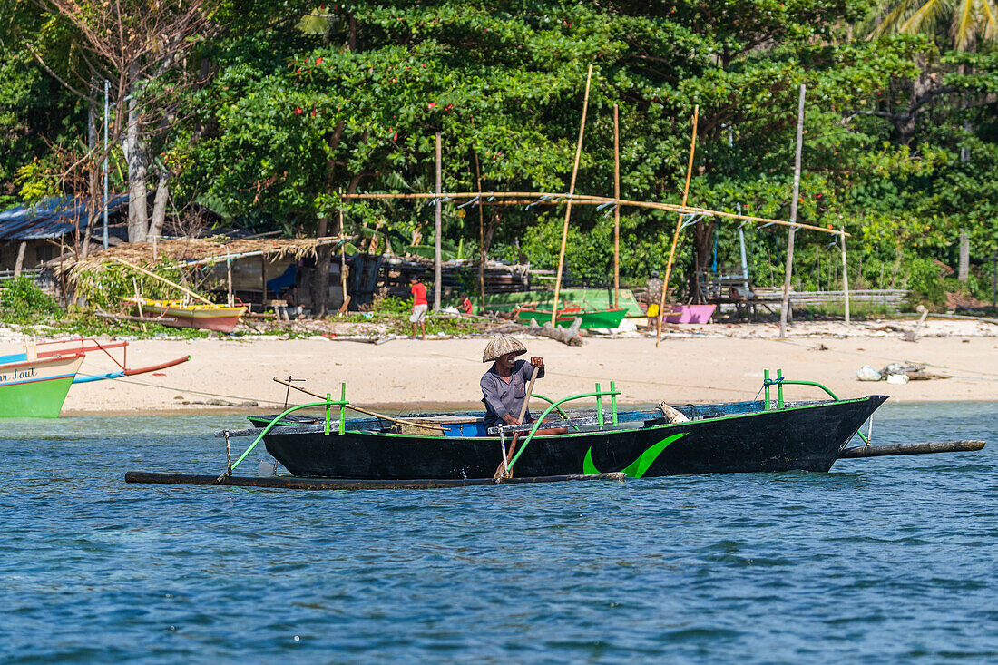 Einheimischer Fischer im Auslegerboot in den flachen Riffen vor der Insel Bangka, vor der nordöstlichen Spitze von Sulawesi, Indonesien, Südostasien, Asien