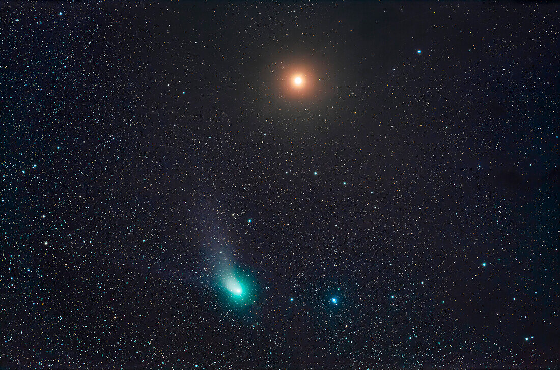The infamous "Green" Comet C/2022 E3 (ZTF) passing by reddish Mars with both in the constellation of Taurus on the night of Feb 11,2023. The comet was 2° south of Mars this night. Mars was embedded in some of the dark obscuring dust clouds in Taurus,creating the dark patchy appearance to the background sky. The comet's coma glows cyan due to emission from diatomic carbon molecules,a common trait of comets. The dust tail and faint ion tail are just visible.
