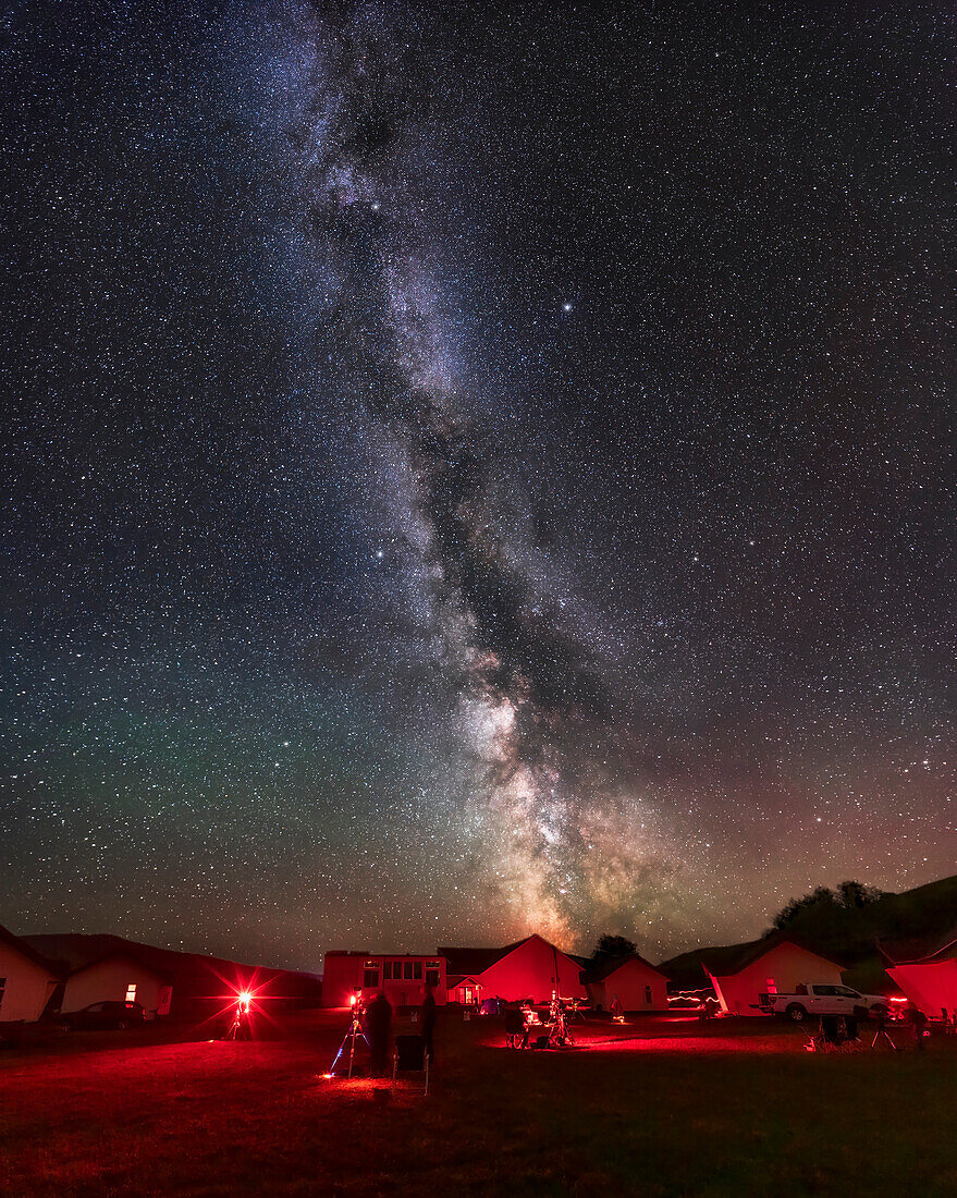 Ein Panorama der sommerlichen Milchstraße von Sagittarius bis zu Cepheus über der Southern Alberta Star Party am 13. September 2023. Die Sternenparty findet in einem Kirchencamp in der Nähe von Elkwater, Alberta in den Cypress Hills statt. Der Himmel ist dort sehr dunkel! Dieses Jahr nahmen etwa 80 Personen teil. Die meisten kümmern sich um ihre Astrofotogeräte. Das Camp hat eine Reihe von Hütten für die Unterbringung und ein Hauptdienstgebäude, das hier im Mittelpunkt steht.