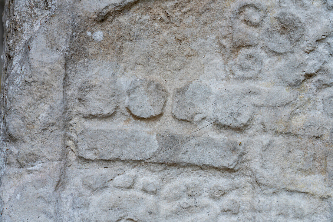Detail einer Glyphe auf Stele 4 in Plaza C der Maya-Ruinen im Yaxha-Nakun-Naranjo-Nationalpark, Guatemala. Diese Glyphe stellt die Zahl 9 dar.