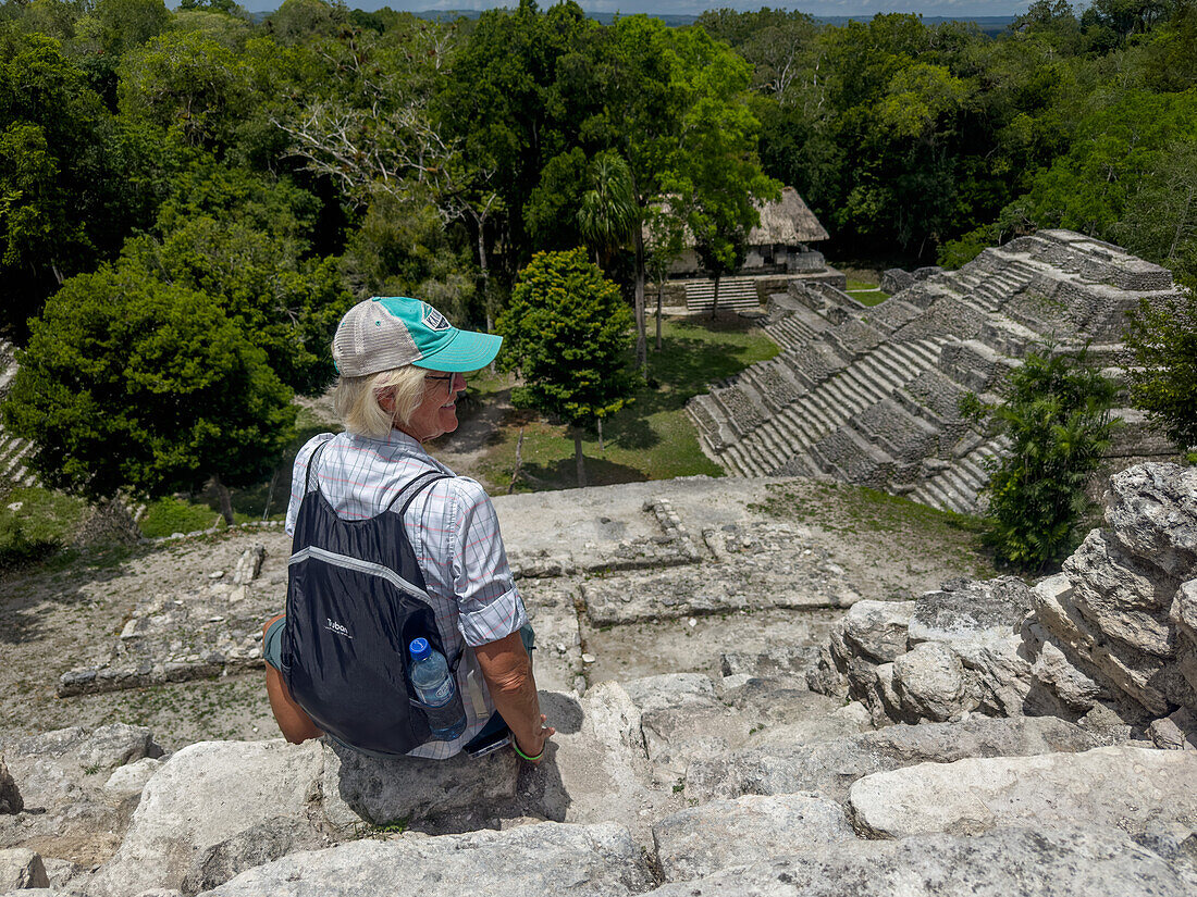 Tourist atop Structure 142,a temple pyramid in the North Acropolis in the Mayan ruins in Yaxha-Nakun-Naranjo National Park,Guatemala. Structure 144 is at right.