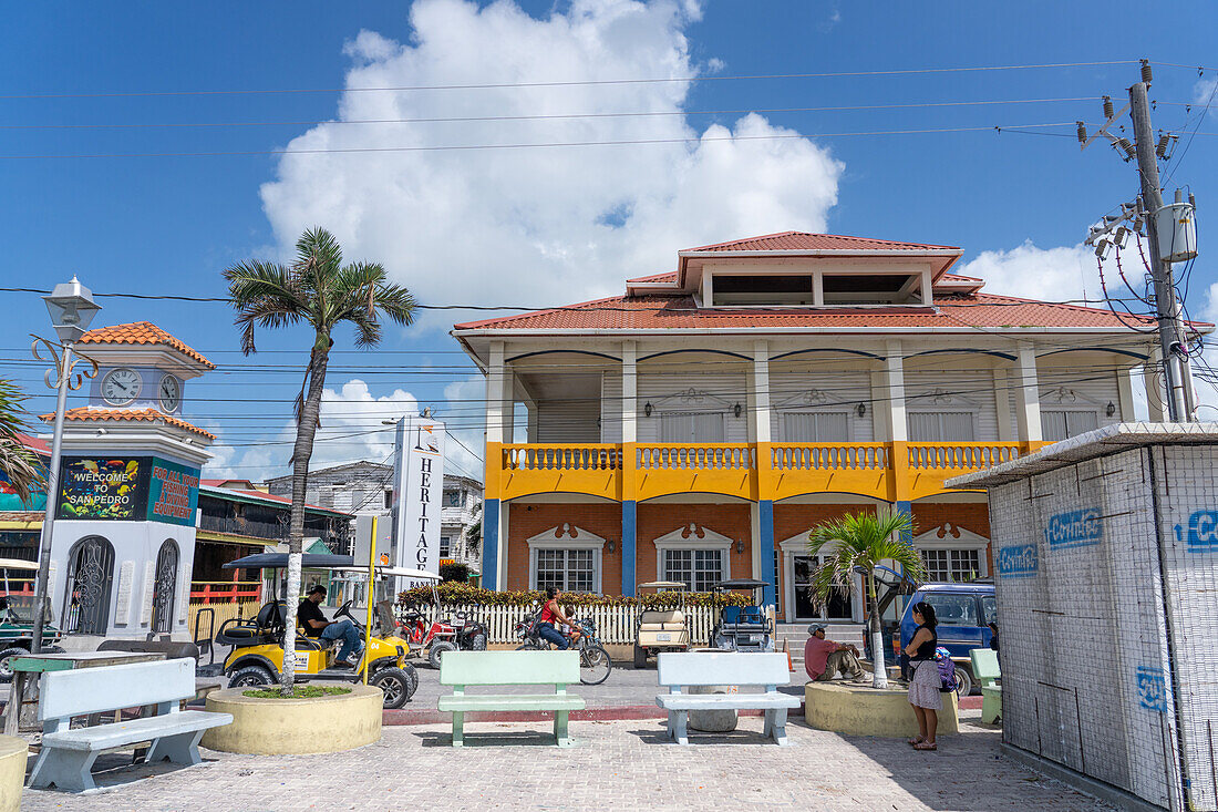 Eine Straßenszene in San Pedro auf Ambergris Caye, Belize. Auf der anderen Straßenseite ist eine Bank im britischen Kolonialstil gebaut.