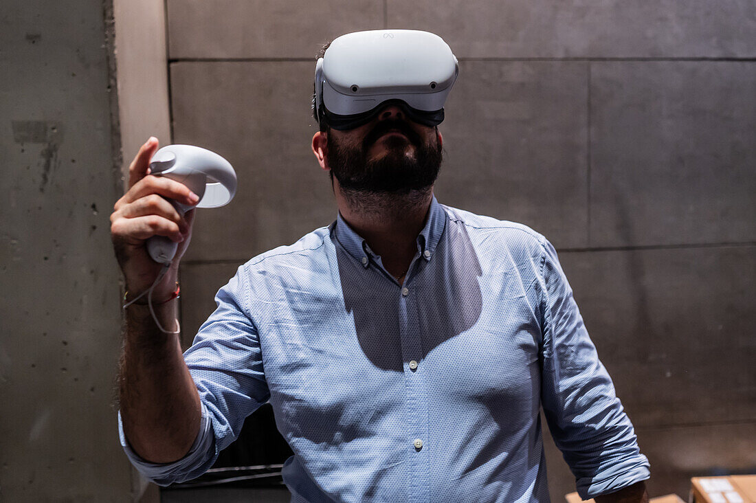 Junger Mann spielt mit dem Meta Quest 2 All-in-One VR-Headset während des ZGamer, einem Festival für Videospiele, digitale Unterhaltung, Brettspiele und YouTuber während der El Pilar Fiestas in Zaragoza, Aragonien, Spanien