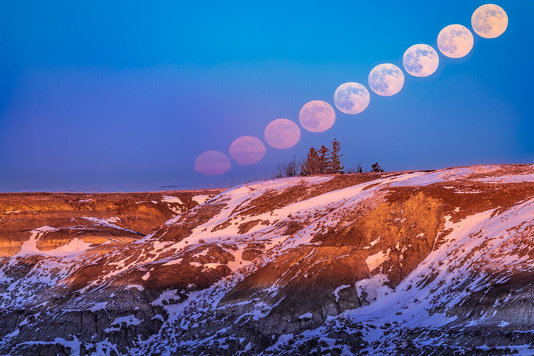 Der aufgehende "Wolf"-Vollmond vom 6. Januar 2023 über den Badlands des Horseshoe Canyon, in der Nähe von Drumheller, Alberta. Die Sequenz zeigt die Farbveränderungen des aufgehenden Mondes durch atmosphärische Absorption und die Veränderungen seiner Form durch atmosphärische Brechung.