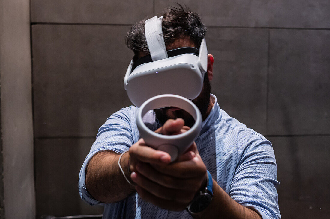 Junger Mann spielt mit Meta Quest 2 All-in-One VR-Headset während ZGamer, einem Festival für Videospiele, digitale Unterhaltung, Brettspiele und YouTuber während der El Pilar Fiestas in Zaragoza, Aragonien, Spanien