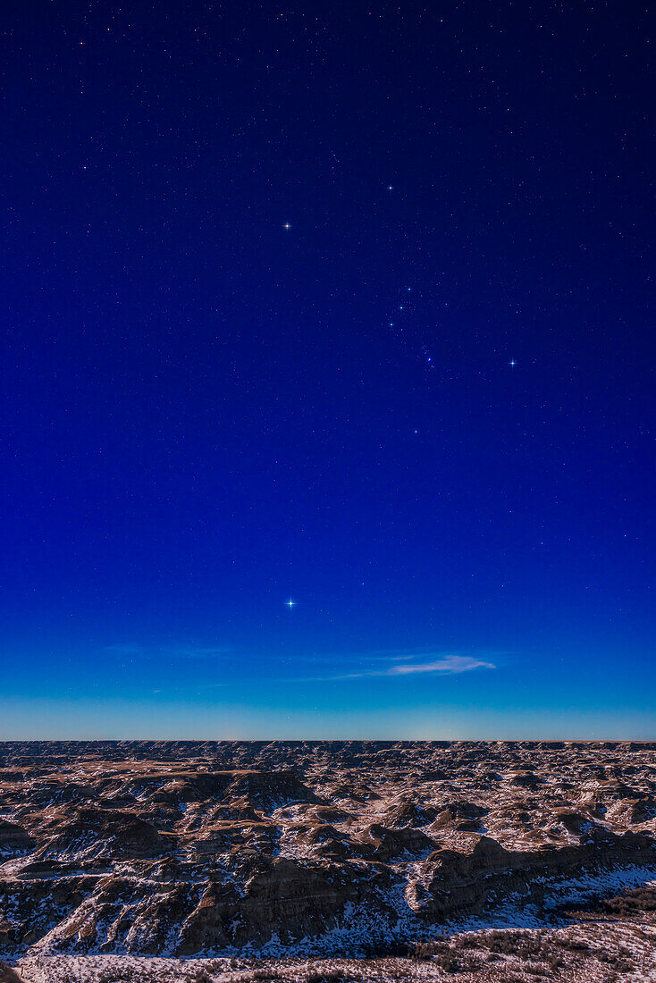 Orion and Sirius over the moonlit badlands of Dinosaur Provincial Park,Alberta on Feb. 4,2023 with the waxing gibbous Moon providing the illumination on this very clear and mild night.