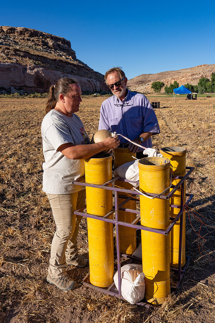Techniker untersuchen eine 8-Zoll-Pyrotechnikhülle, die auf einem Feld in Utah für eine Feuerwerksshow vorbereitet wird.