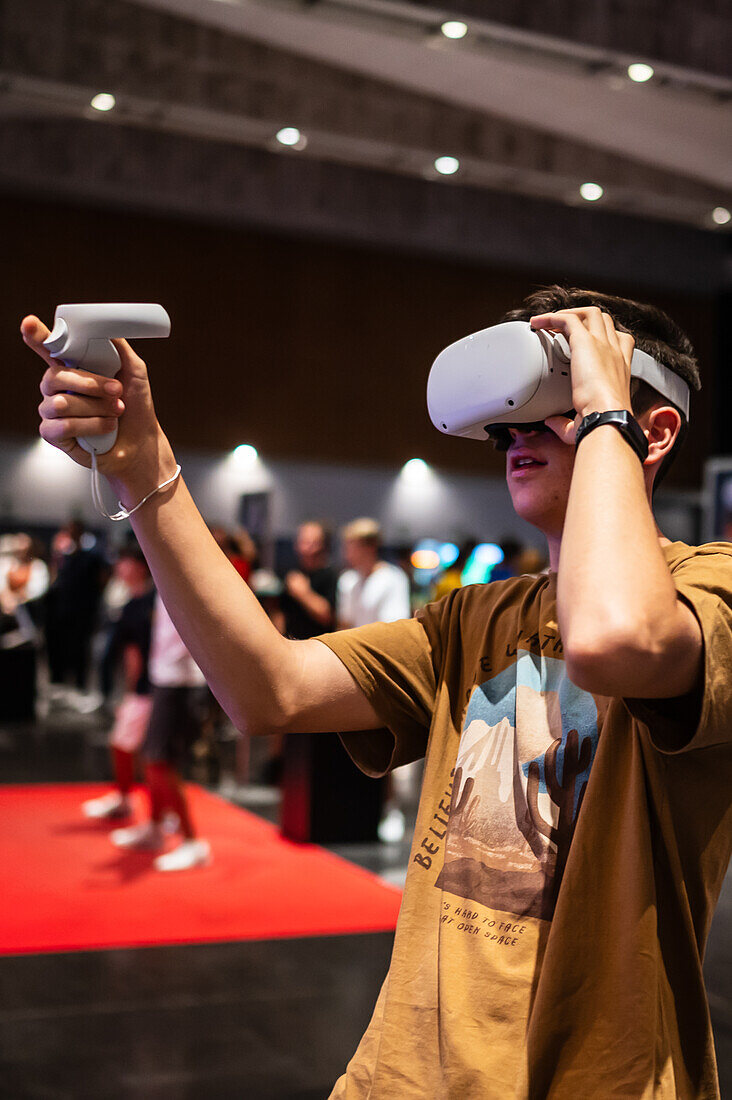Teenager spielt mit dem Meta Quest 2 All-in-One VR-Headset während des ZGamer, einem Festival für Videospiele, digitale Unterhaltung, Brettspiele und YouTuber während der El Pilar Fiestas in Zaragoza, Aragon, Spanien