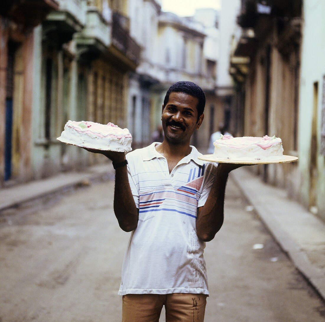 Kubanischer Bäckereigehilfe mit zwei Torten auf der Strasse