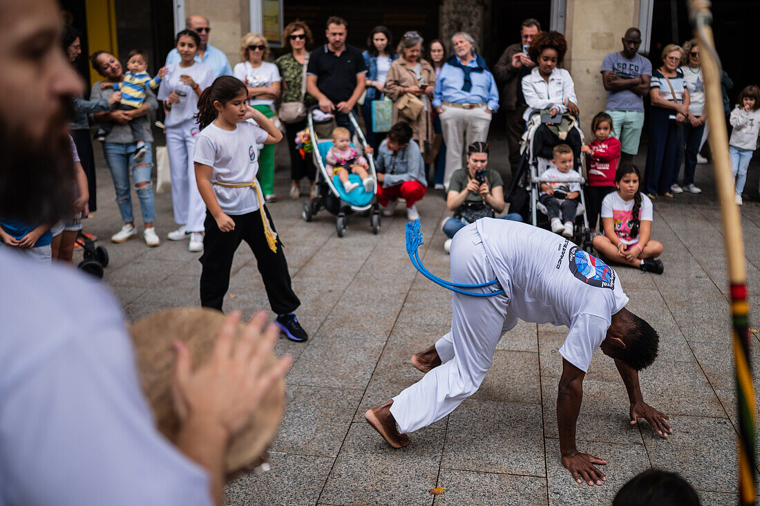 Mitglieder der Mestre Branco Capoeira Escola demonstrieren auf der Straße während der Fiestas von El Pilar in Zaragoza, Aragonien, Spanien