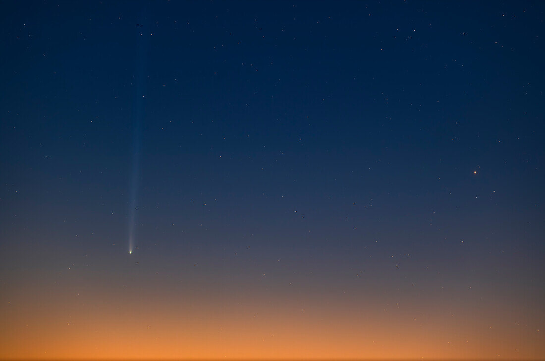 Komet Nishimura (C/2023 P1), links, aufgenommen etwa 30 Minuten nach seinem Aufgang am Himmel in der Morgendämmerung am 10. September 2023, wobei der Himmel in den Farben der Morgendämmerung erstrahlte. Der Komet befand sich zu diesem Zeitpunkt nur etwa 4,5º über dem Horizont.