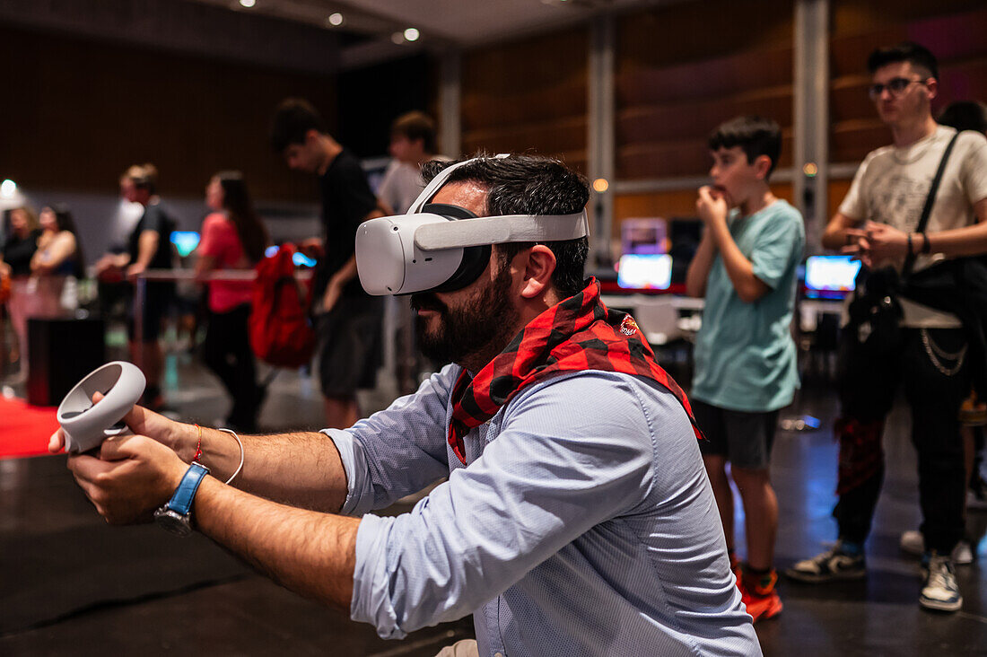 Junger Mann spielt mit dem Meta Quest 2 All-in-One VR-Headset während ZGamer, einem Festival für Videospiele, digitale Unterhaltung, Brettspiele und YouTuber während der El Pilar Fiestas in Zaragoza, Aragonien, Spanien