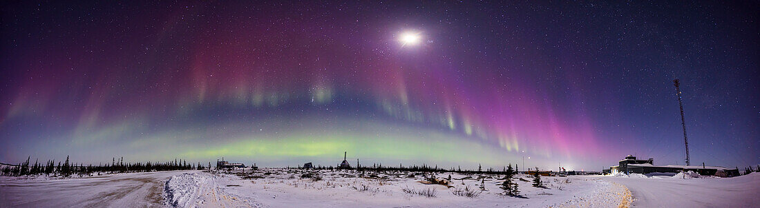 A 220° panorama of a dimmer but colourful aurora on a Kp6 night on February 26,2023,from the Churchill Northern Studies Centre,Churchill,Manitoba,at 58° N. This is mostly looking south over the old Rocket Range,with the waxing Moon prominent at centre in Taurus near the Pleiades and above Orion.
