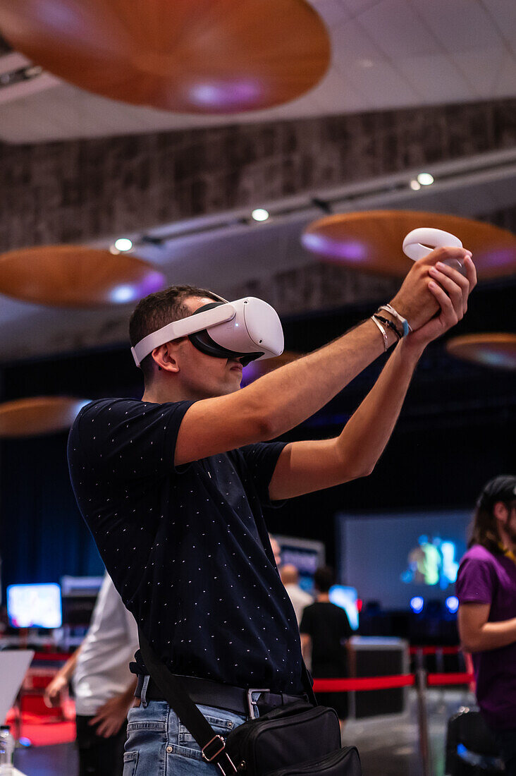 Junger Mann spielt mit Meta Quest 2 All-in-One VR-Headset während ZGamer, einem Festival für Videospiele, digitale Unterhaltung, Brettspiele und YouTuber während der Fiestas del Pilar in Zaragoza, Aragonien, Spanien