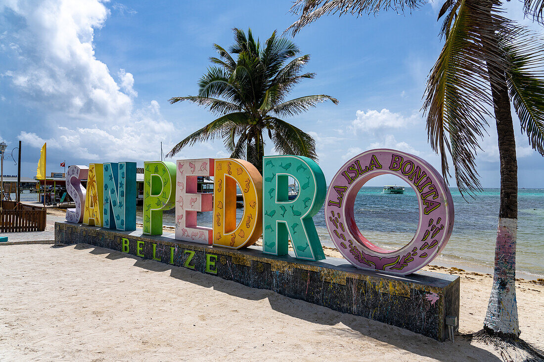 Ein Boot, eingerahmt von einem 3-D-Schild am Strand von San Pedro auf Ambergris Caye, Belize.