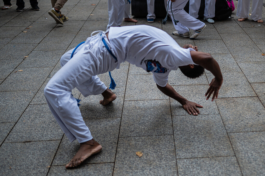 Mitglieder der Mestre Branco Capoeira Escola demonstrieren auf der Straße während der Fiestas del Pilar in Zaragoza, Aragonien, Spanien