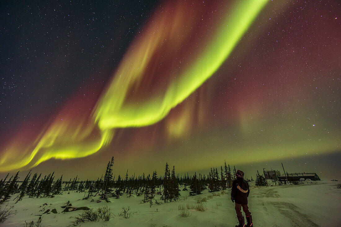 Ein Polarlicht-Selfie unter dem Bogen des Nordlichts am 22. Februar 2023 auf der Rocket Range Road vor dem Churchill Northern Studies Centre in Churchill, Manitoba. Blick nach Südosten. Es handelte sich um eine Kp5-Anzeige in dieser Nacht, die zwischen 20:30 und 21:30 Uhr ihren Höhepunkt erreichte.